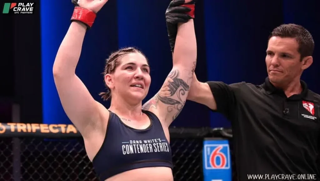 MMA fighter raising her both hands after winning the match